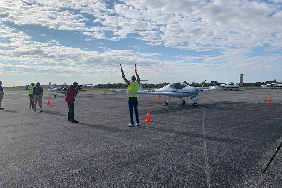 Hudson Pettit, center, assists a Flying Billiken teammate as they land at St. ˻ֱ Downtown Airport on Thursday, Oct. 19.  Photo by Maggie Rotermund. 